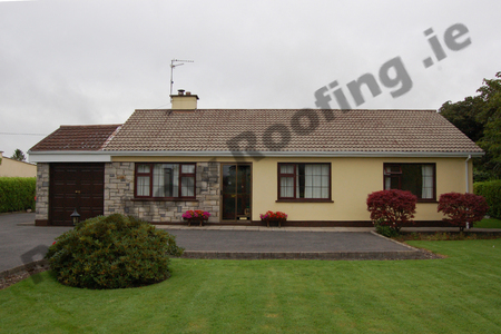 Small bungalow house roof with faded roof tiles
