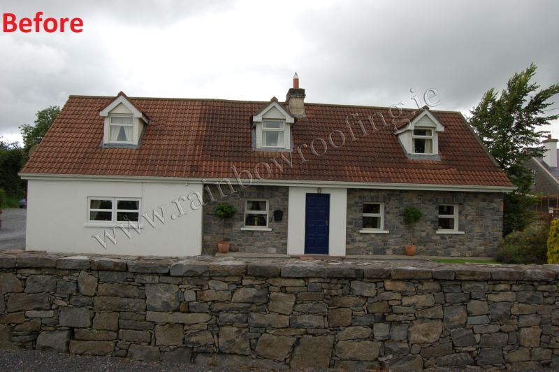 Small bungalow house roof with faded roof tiles of varying colours