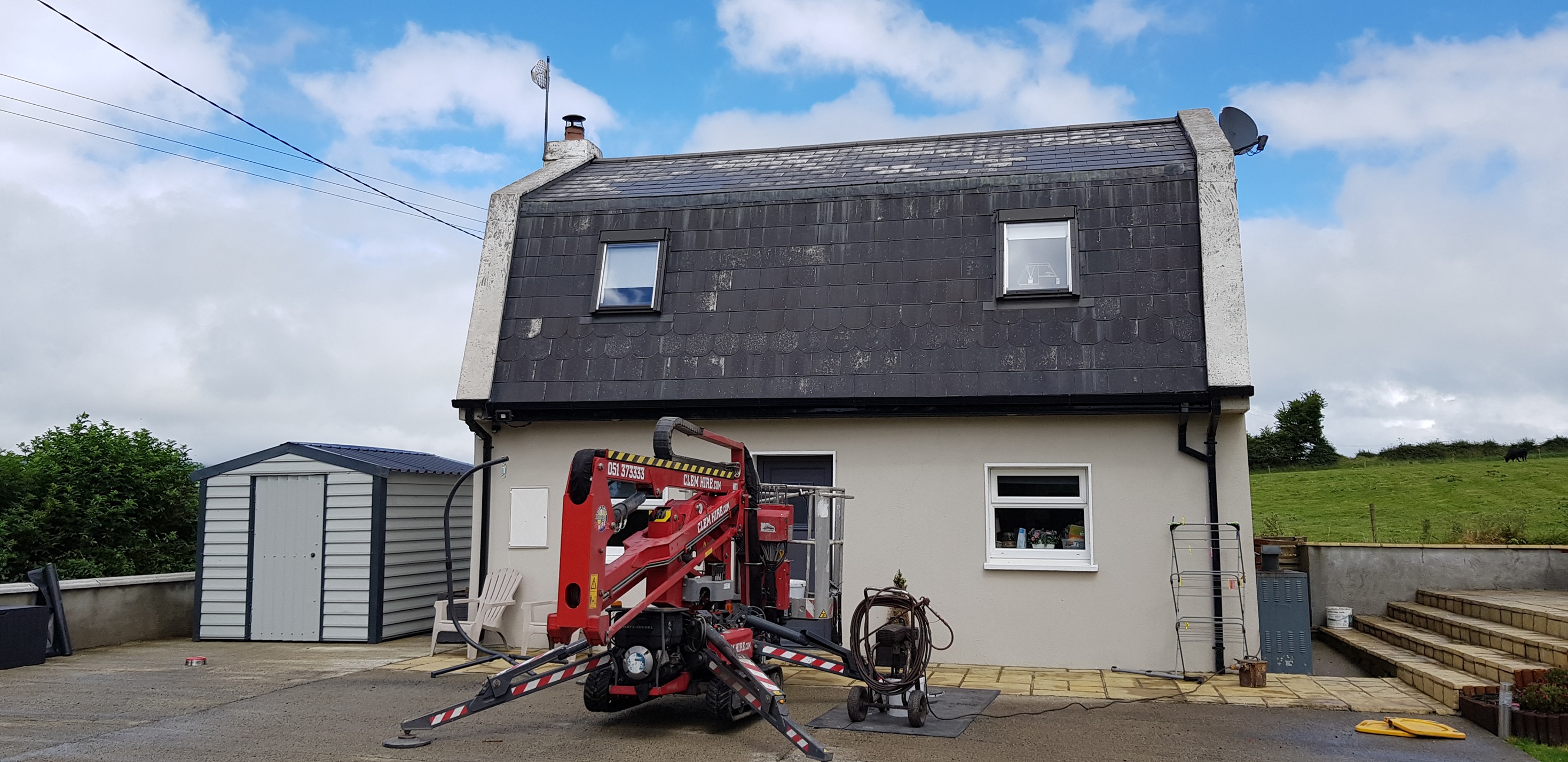 cherrypicker being used inspecting painted roof tiles for maintenance