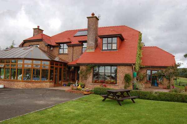 Red Roof House that has had its roof tiles painted with a fresh coat of roof paint.
