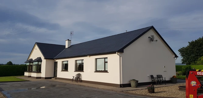 A bungalow house that has had its roof tiles painted and restored with a roof spray coating
